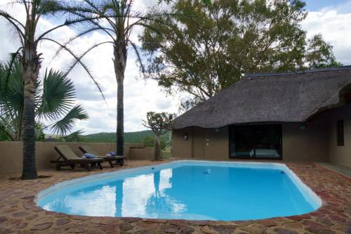 a swimming pool in a yard next to a house at Thaba Pitsi Safari Lodge in Bela-Bela