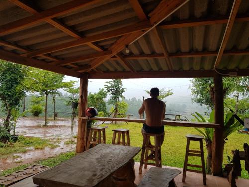 a man is standing on a table in a house at Monsonkeang Camping view ม่อนสันเกี๋ยง in Mae Chaem