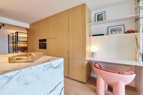 a kitchen with a pink chair and a counter at Suite Riverside in Nieuwpoort