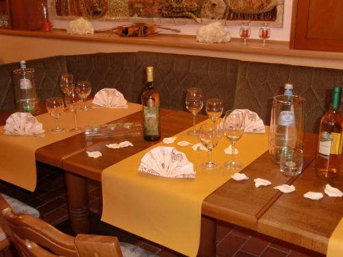 a table with wine bottles and wine glasses on it at Hotel Heidehof in Königswartha