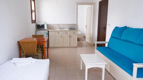 a living room with a blue couch and a kitchen at Gumbet Cove Hotel in Gümbet