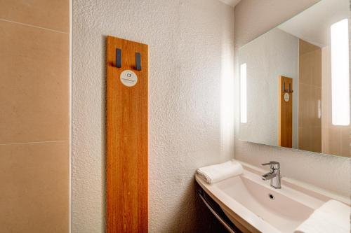 een badkamer met een wastafel en een spiegel bij B&B HOTEL Saint-Witz in Saint-Witz