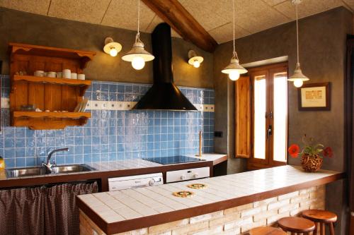 cocina con paredes de azulejos azules y encimera en 6 bedrooms villa with private pool and wifi at Llobera en Llanera