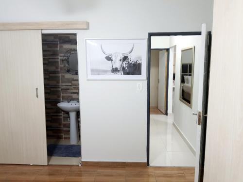 a bathroom with a door with a picture of a bull at NST City Apartments @ Casalinga Villa in Nelspruit