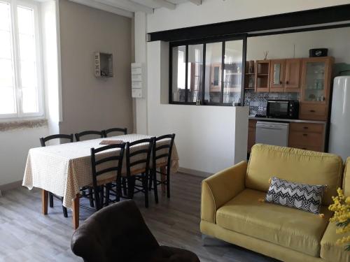 un salon avec une table, des chaises et un canapé dans l'établissement Gîte de La Ribotière à 15 min du Puy du Fou, à Pouzauges