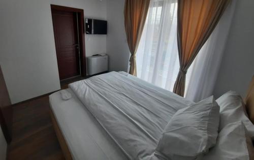 a bed sitting in a room with a window at Wine Cellar Popovi Apartments & Wine Tasting in Kavadarci
