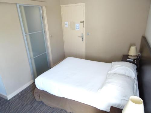 a bedroom with a white bed and a glass door at SOWELL HOTELS Domaine de la Petite Isle in LʼIsle-sur-la-Sorgue