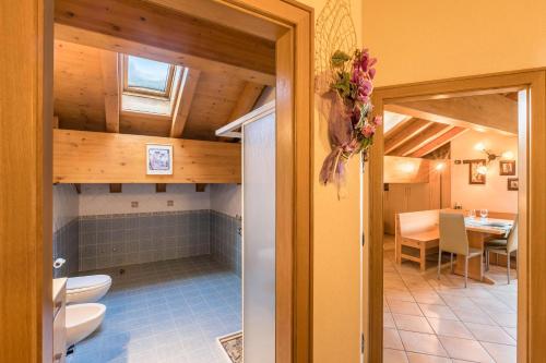 a bathroom with a toilet and a sink and a table at Zenith - Casa Azzurra Mansarda in Livigno