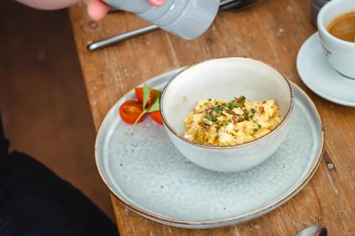 a bowl of food on a plate with a cup of coffee at Der Steinerwirt - hangout & hotel in Lofer