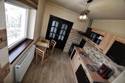eine kleine Küche mit einem Tisch und einem Fenster in der Unterkunft FLORI'S Apartment in Braşov