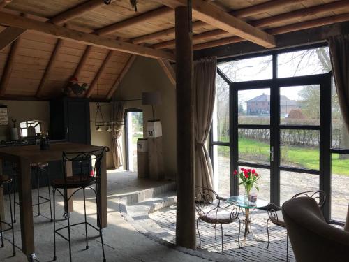 een kamer met een tafel en stoelen en een groot raam bij De Grote Belt in Oene