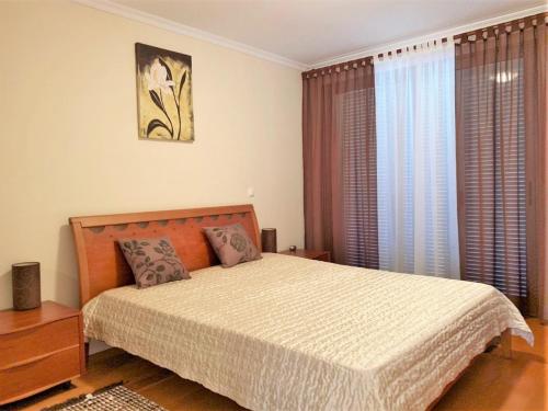 a bedroom with a bed and a large window at Charming Calheta Plaza Penthouse in Calheta