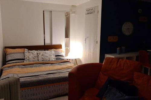 sypialnia z łóżkiem, krzesłem i lampką w obiekcie Studio de charme pour concentration et détente w mieście Houilles