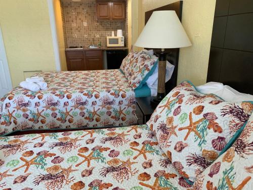 a hotel room with two beds and a lamp at Sandy Shores Resort in North Wildwood