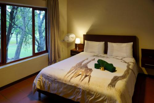 a bedroom with a bed with a giraffe decoration on it at Thaba Pitsi Safari Lodge in Bela-Bela
