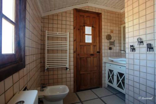 a bathroom with a sink and a toilet and a door at Room in Bungalow - Bungalow Double 7 - El Cortijo Chefchaeun Hotel Spa in Chefchaouen