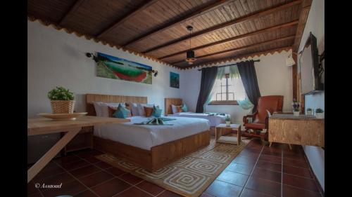 a bedroom with two beds and a desk in it at Room in Bungalow - Bungalow Double 13 - El Cortijo Chefchaeun Hotel Spa in Chefchaouen