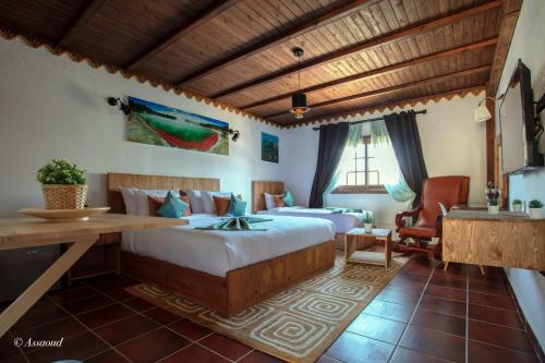 a bedroom with two beds and a desk in a room at Bungalow Double 18 - El Cortijo Chefchaeun Hotel Spa in Chefchaouene