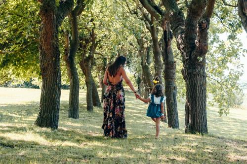 a woman and a little girl walking through a park at Collina dei Poeti in Santarcangelo di Romagna