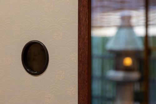 a door with a round mirror on a wall at 祇園の宿 杏花 in Kyoto