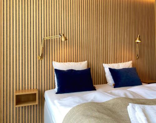 a hotel room with two beds with blue pillows at Skagen Harbour Hotel in Skagen