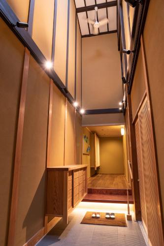a hallway of a building with a table and lights at 祇園の宿 杏花 in Kyoto