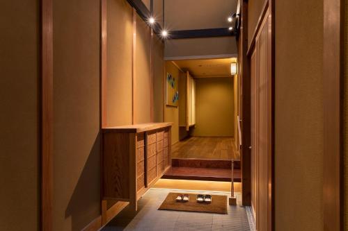 um corredor com uma casa de banho com uma cabina de duche ao nível do chão em 祇園の宿 杏花 em Quioto