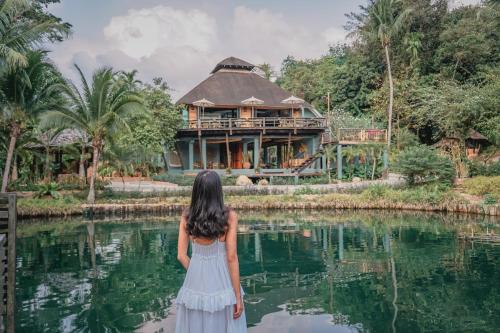 a young girl standing in front of a house at The Spa Koh Chang Resort in Ko Chang