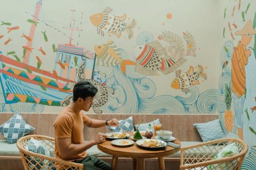 a man sitting at a table with a plate of food at The Spa Koh Chang Resort in Ko Chang