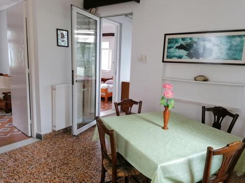 a dining room with a green table with a vase on it at Faneromeni Two bed Apartment B (1st Floor) in Zakynthos Town