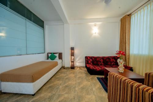 a hotel room with a bed and a couch at Olympus Plaza Hotel in Haputale