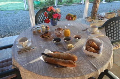 einen Tisch mit einem Frühstück mit Brot und Gebäck darauf in der Unterkunft LA PASTORALE in Beurlay