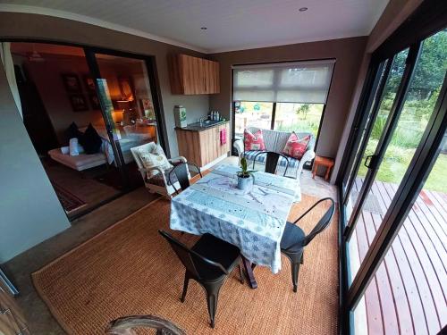 um quarto com uma mesa e cadeiras e uma cozinha em Cavalo Guesthouse & Equestrian Estate em Drummond
