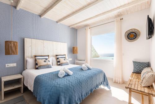 een slaapkamer met een bed met blauwe muren en een raam bij Suites Las Vistas by Menorca Vacations in Son Bou