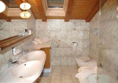 a bathroom with a tub and a sink and a toilet at Garni Winklerhof in Lagundo