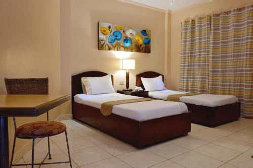 um quarto com 2 camas, uma mesa e uma secretária em Palazzo Pensionne em Cebu