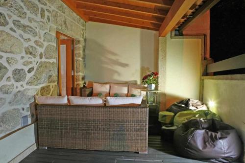 sala de estar con sofá y pared de piedra en Casa das Pesqueiras, en Melgaço