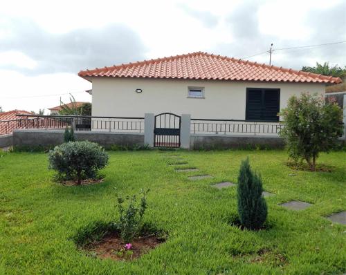 a white house with a fence and a yard at Villas Madalena Chalets vista mar cWiFi in Santa Cruz