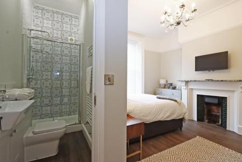 a bedroom with a bed and a bathroom with a fireplace at No.31 Castle Gate in Newark-on-Trent