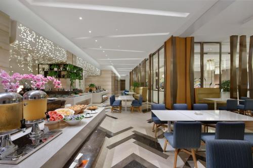 a restaurant with tables and chairs and a buffet at Holiday Inn Express Chengdu Huanhuaxi by IHG-Near Jinsha Site Musem,Near Wuhou Temple Museum,Welcome drinks,Free gym,Free self-service laundry in Chengdu