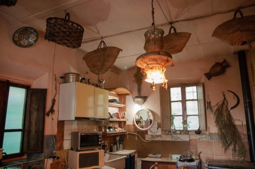 cocina con cestas colgadas del techo y microondas en Centro Studi Nuovarmonia, en Cedri
