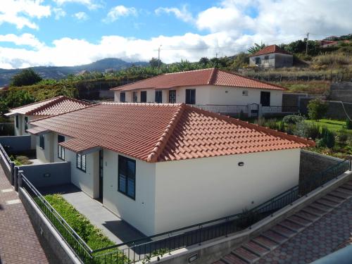 a white house with a red tile roof at Villas Madalena Chalets vista mar cWiFi in Santa Cruz