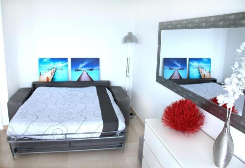 1 dormitorio con cama y espejo grande en Le Riviera Plage, en Niza