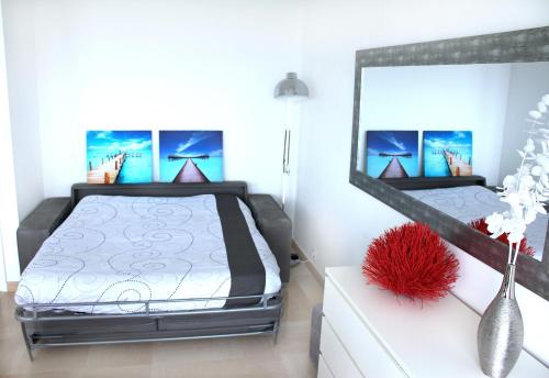 une chambre avec un lit et un grand miroir dans l'établissement Le Riviera Plage, à Nice