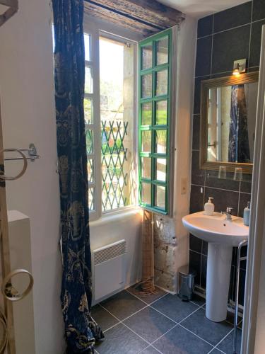 Villa Marguerite Chambres et Table d Hotes de charme في Cadouin: حمام مع حوض ومغسلة ونافذة