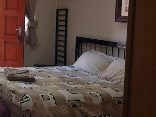 a bedroom with a bed with a blanket on it at Country Blue Luxury Guest House in Polokwane