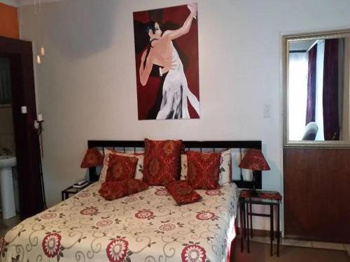 a bedroom with a bed with a painting on the wall at Country Blue Luxury Guest House in Polokwane