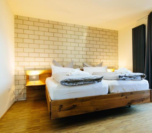 two twin beds in a room with a brick wall at Apartmenthotel Oberstdorf in Oberstdorf