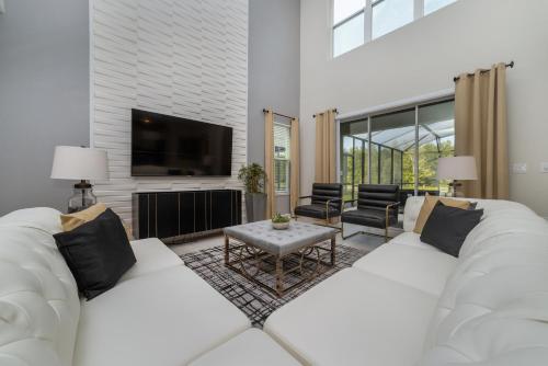 a living room with two white couches and a tv at Villa wPrivate Pool &Themed Rooms, near Disney in Kissimmee