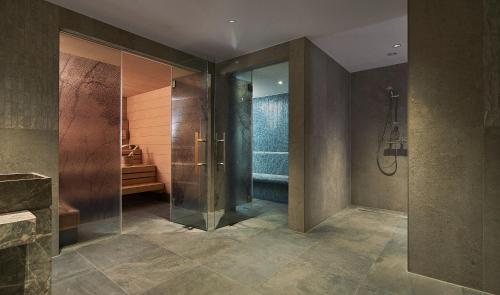 ein Bad mit einer Dusche und einer ebenerdigen Duschkabine in der Unterkunft The Market Hotel in Groningen